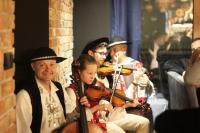 um grupo de pessoas tocando violinos em um concerto em Willa ŻeglarSki em Kluszkowce