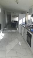 a kitchen with white tile floors and a dining room at Paranthese à Marennes in Marennes