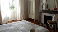 a bedroom with a fireplace and a bed and a window at L&#39;Ecrin in Villeneuve-sur-Lot