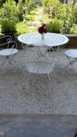 a white table and chairs with a vase of flowers on it at L&#39;Ecrin in Villeneuve-sur-Lot