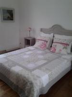 a bedroom with a large bed with pink and white pillows at L&#39;Ecrin in Villeneuve-sur-Lot