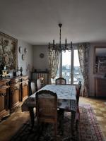 a dining room with a table and chairs and a window at Suite Clémenceau 82 in Reims