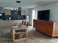 a kitchen with a table with chairs and a television at La Maison Trésallet in La Plagne Tarentaise