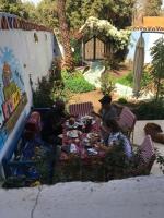 Un grupo de personas sentadas en una mesa comiendo comida en The Mango Guest House, en Asuán