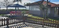 a wooden fence in front of a house with a gazebo at Hotel Nils in Itapoa