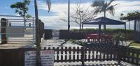 a fence with a table and an umbrella on the beach at Hotel Nils in Itapoa