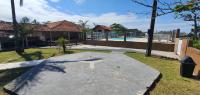 a stone walkway in a yard with a pool at Hotel Nils in Itapoa