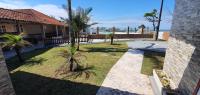a yard with palm trees in front of a house at Hotel Nils in Itapoa