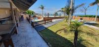 a walkway next to a beach with palm trees at Hotel Nils in Itapoa