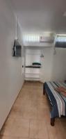 a small room with a bed and a window at Hotel Nils in Itapoa