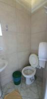 a bathroom with a toilet and a sink at Hotel Nils in Itapoa