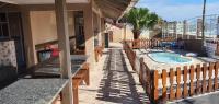 an outdoor patio with a swimming pool and a building at Hotel Nils in Itapoa