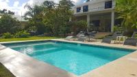 una piscina con sillas y una casa en La Belle Créole, en Las Galeras