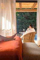 a man sitting in a chair talking on a cell phone at Lares De Chacras in Chacras de Coria