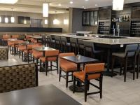 a restaurant with tables and chairs and a bar at Holiday Inn Champaign by IHG in Champaign