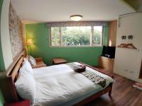 a bedroom with a white bed in a room with a window at Hejia B&amp;B in Hualien City