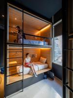 a woman sitting on a bed in a bunk room at The Bed KLCC in Kuala Lumpur
