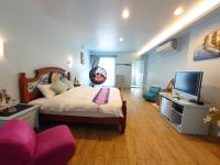 a bedroom with a large bed and a television at Lotus Hostel Beicheng Zhuang in Luodong
