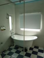 a white bath tub in a bathroom with a window at Lotus Hostel Beicheng Zhuang in Luodong