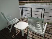 two chairs and a table on a balcony with the water at Lotus Hostel Beicheng Zhuang in Luodong