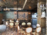 ein Restaurant mit Tischen und Stühlen in einem Raum in der Unterkunft Apartment ALPINE by Atrium, New Gudauri in Gudauri