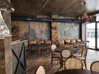 ein Restaurant mit Tischen und Stühlen in einem Raum in der Unterkunft Apartment ALPINE by Atrium, New Gudauri in Gudauri