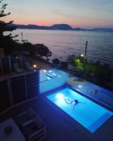 a person swimming in a swimming pool at night at Valtes Luxurious Apartments in Mpoukaris