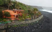 a house on a hill next to the ocean at Tortuga B&amp;B in São Filipe