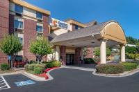 Un hotel con un estacionamiento enfrente. en Comfort Inn &amp; Suites Suwanee - Sugarloaf, en Suwanee