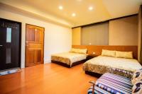 a hotel room with two beds and a door at Wenxin Homestay in Hualien City