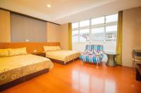 a hotel room with two beds and a chair at Wenxin Homestay in Hualien City