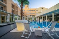 una piscina con 2 sillas y un hotel en Hotel de Ilhavo Plaza &amp; Spa, en Ílhavo