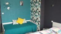 a bedroom with a green bed with a yellow pillow at Les Chambres de l&#39;Ile in Metz
