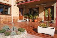 Un patio con plantas en macetas frente a un edificio. en Hostal El Mirador, en La Lastrilla