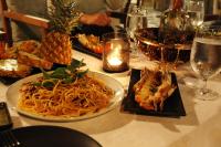 a table with a plate of spaghetti and other foods at De Lit in Ubon Ratchathani