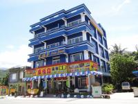 a tall blue building with colorful signs on it at Sansendai Sea View B&amp;B in Chenggong