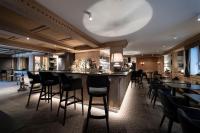 a bar in a restaurant with black bar stools at Alpstay - Hotel Acadia - Adults Mountain Home in Selva di Val Gardena