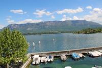 a group of boats docked in a lake with mountains at RESIDENCE DU PORT in Le Bourget-du-Lac