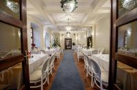 Un comedor con mesas y sillas blancas. en Pałac w Rymaniu, en Rymań