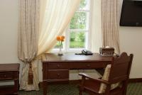 a desk with a window with a vase of flowers at Bistrampolis Manor in Kučiai