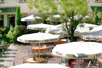 un grupo de mesas con sombrillas en un patio en Hotel Watthalden, en Ettlingen