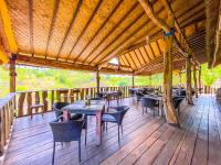 un ristorante con tavoli e sedie su una terrazza in legno di Namaste Bungalows a Nusa Penida