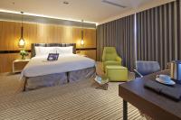 a hotel room with a bed and a chair and a desk at La Vida Hotel in Taichung