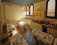 a kitchen with tables and chairs and a large screen at Hotel Torino in Venice