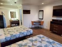 a room with two beds and a table and a mirror at Studio 6-National City, CA - Naval Base San Diego in National City