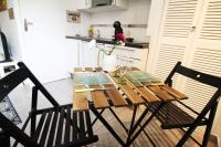 a dining room table with two chairs in a kitchen at STUDIO COSY LE Ti PARIS WIFI &amp; NETFLIX in Deuil-la-Barre