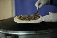 une personne préparant une pizza sur une table à l'aide d'une spatule dans l'établissement Princessa Hotel, à Jounieh