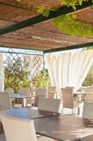 un patio con mesas, sillas y cortinas blancas en Do Ciacole In Relais, en Mira
