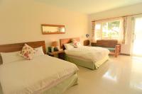 a bedroom with two beds and a window at Kenting COMIC B&amp;B in Hengchun South Gate