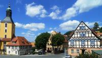 a town with buildings and a church and a street at MB Hotel Weißer Hirsch in Hohnstein